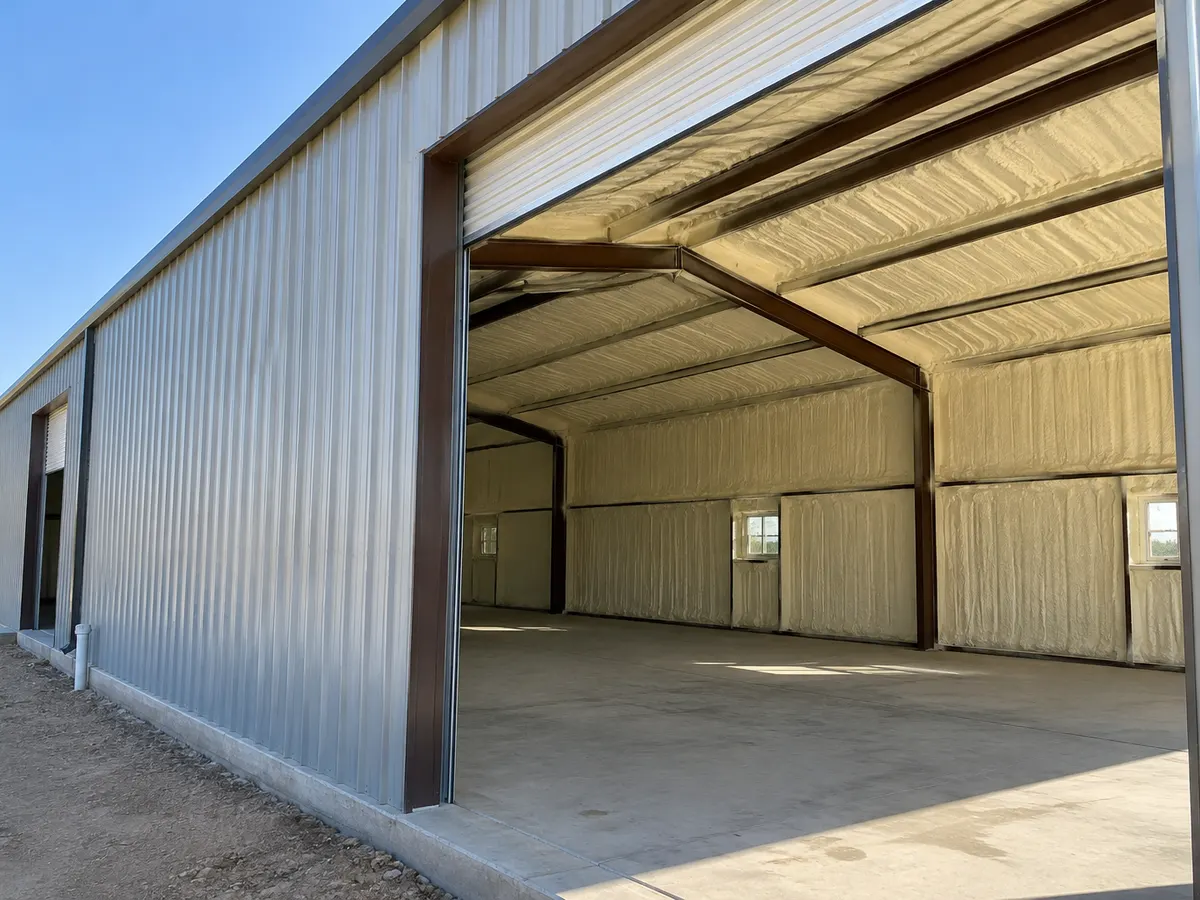 Illustration of a modest steel outbuilding with an open door and selected roofline insulation