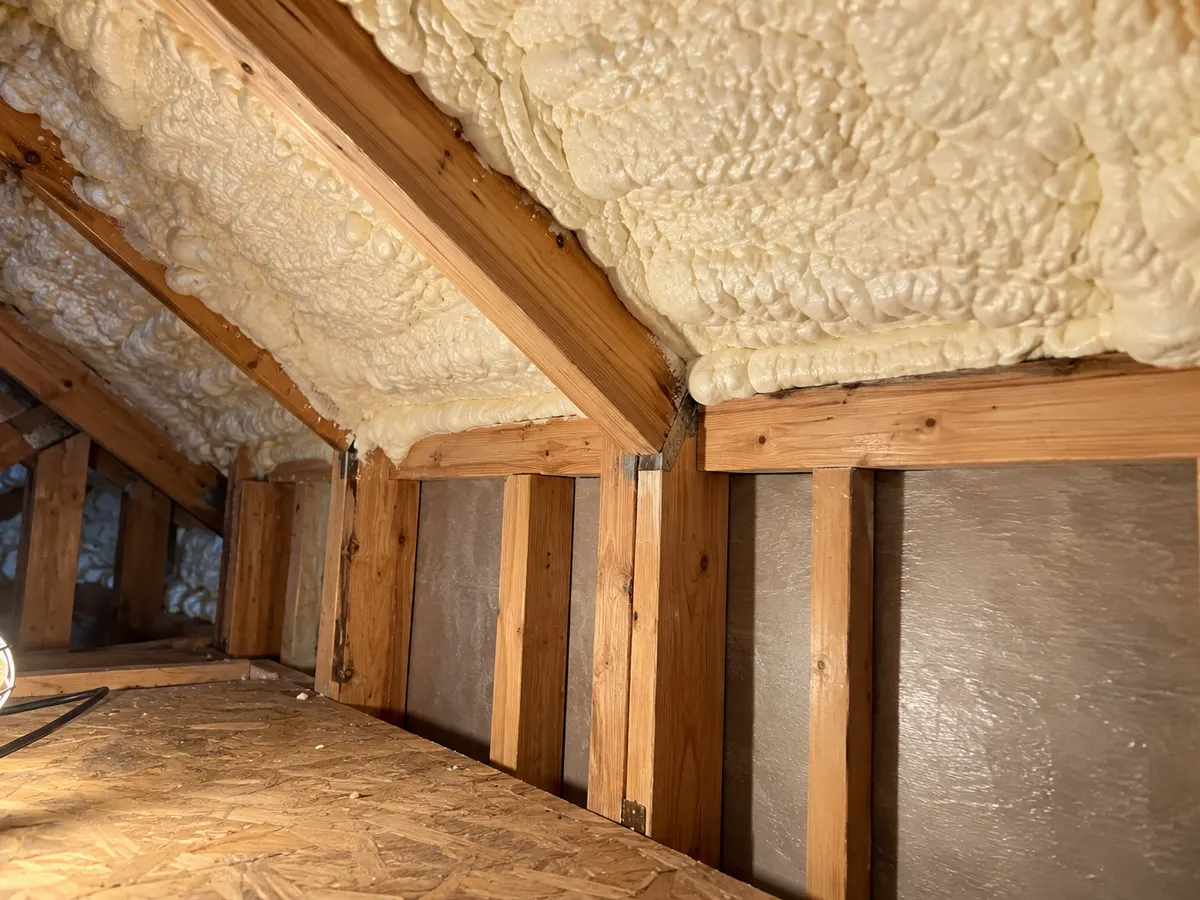 Illustration of an attic-to-wall edge with selected foam coverage and clear framing access