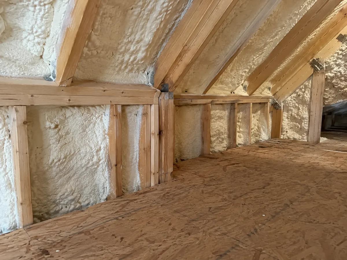 Illustration of inside attic view of the connection around a short wall and floor edge over a garage, insulated timber framing