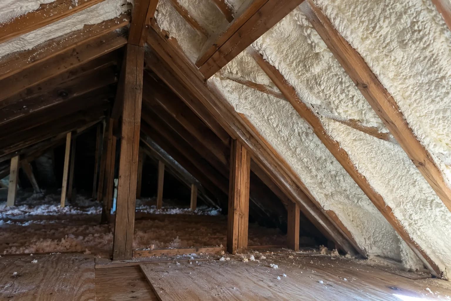 Illustration of existing house attic with aged rafters and white roofline foam, asymmetrical cross-gable junction, side daylight