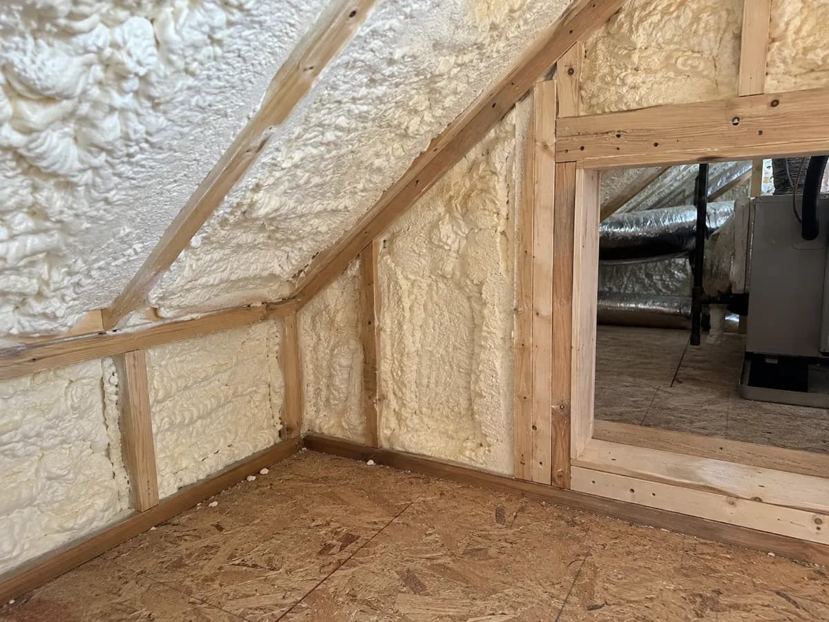 Illustration of insulated attic knee-wall and sloped ceiling junction beside an accessible service opening