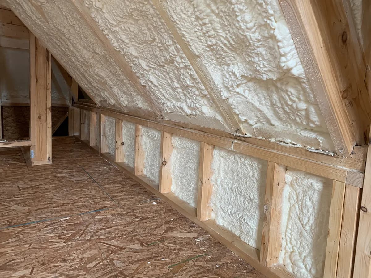 Illustration of detailed attic knee-wall return and roof foam connection with natural lumber