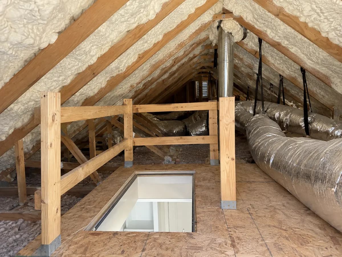 Illustration of attic roof slope with white foam and a protected hatch platform near a visible exhaust service route