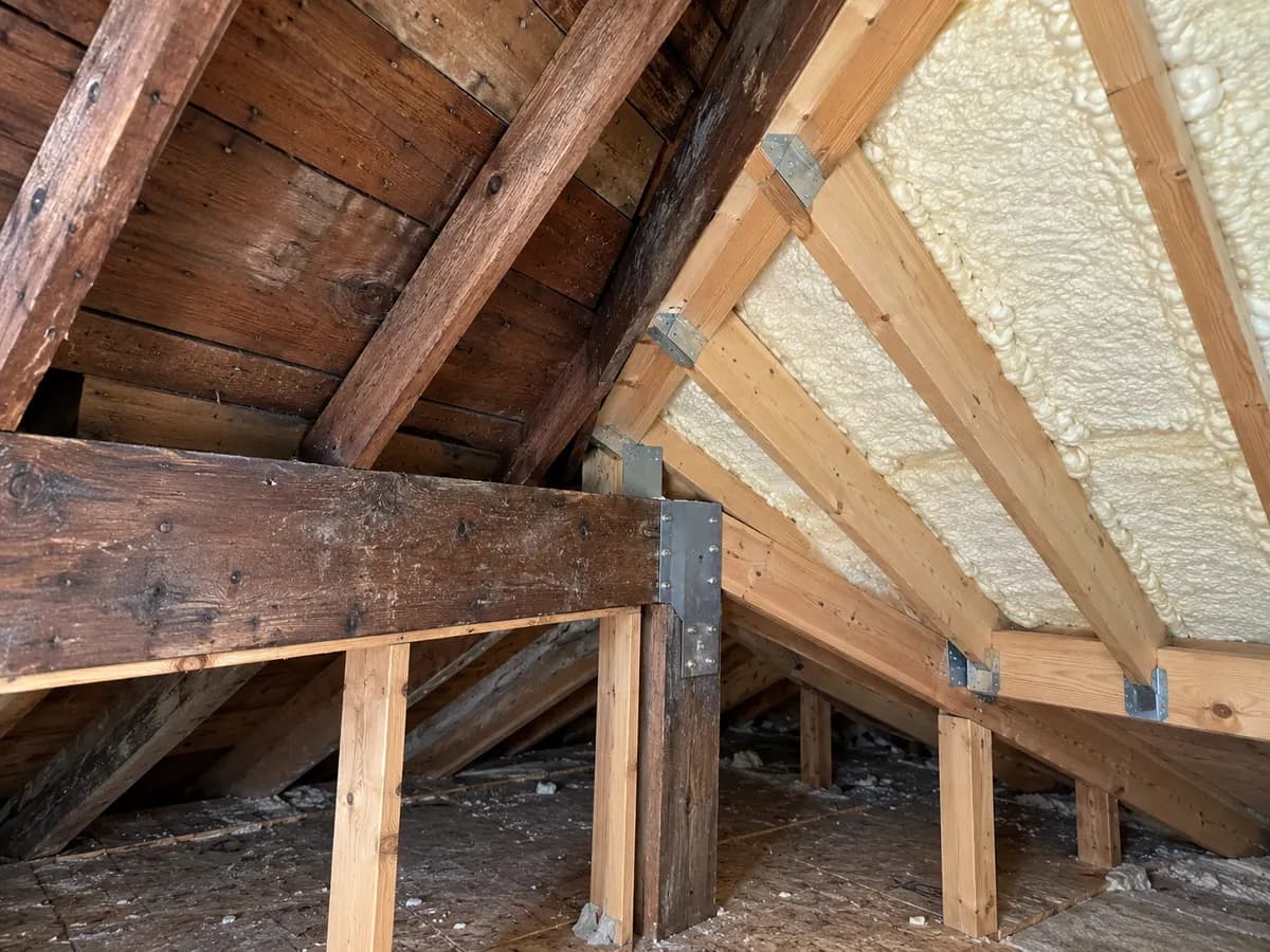 Illustration of attic junction joining older timber and an addition roof, pale foam in accessible bays