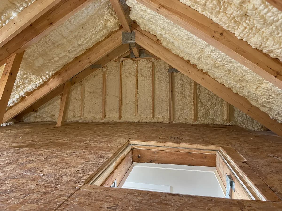 Illustration of attic wall-top and sloped roof transition with cream foam and a clear hatch landing